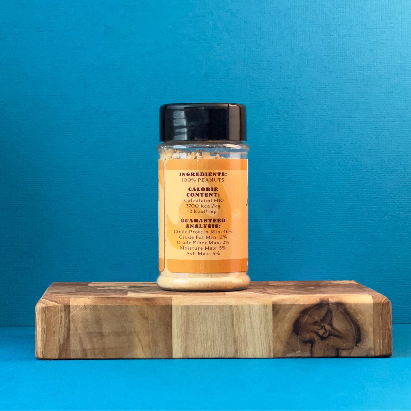 peanut butter powder on a wooden block against a blue background