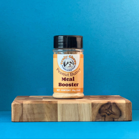 Jar of 'Meal Booster' on a wooden block against a blue background