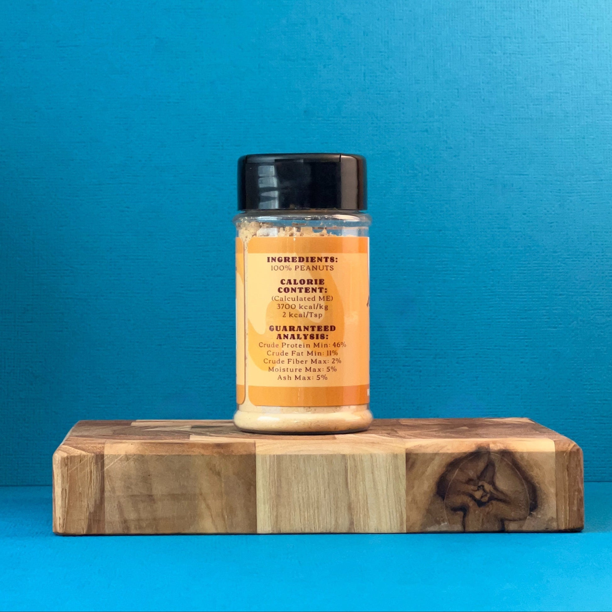 peanut butter powder on a wooden block against a blue background